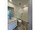 Well-lit bathroom featuring white cabinets, granite countertop, mirror, tiled shower, and wood-look flooring at 16562 E 109Th Ave, Commerce City, CO 80022