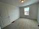 Bright bedroom with neutral carpet, white walls, a window, and a light fixture at 16562 E 109Th Ave, Commerce City, CO 80022