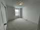 Cozy bedroom features neutral carpet, white walls, a light fixture, and a window providing natural light at 16562 E 109Th Ave, Commerce City, CO 80022