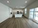 Open-concept kitchen with white cabinets and stainless steel appliances at 16562 E 109Th Ave, Commerce City, CO 80022