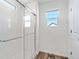 Bright bathroom featuring a glass-enclosed shower, window, and wood-style flooring for a modern aesthetic at 22123 E 38Th Pl, Aurora, CO 80019