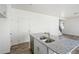 Kitchen with center island featuring a stainless steel sink, granite countertops, and white cabinets at 22123 E 38Th Pl, Aurora, CO 80019