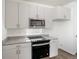 Modern kitchen features stainless steel appliances, granite countertops, and white cabinetry at 22123 E 38Th Pl, Aurora, CO 80019
