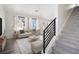 Bright living room with modern decor, light-colored furniture, and a staircase to the side at 22123 E 38Th Pl, Aurora, CO 80019