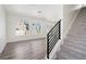 Bright living room featuring hardwood floors, large windows, and a staircase with carpeted steps at 22123 E 38Th Pl, Aurora, CO 80019