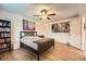 Bedroom features hardwood floors, a large bed frame, a bookshelf, and artwork hanging on the walls at 19196 E Kansas Dr, Aurora, CO 80017