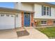 Close-up of home's inviting blue front door with wreath, brick accents, and attached garage at 19196 E Kansas Dr, Aurora, CO 80017