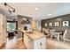 Open-concept kitchen with hardwood floors, modern island, and seamless flow to living area and dining at 19196 E Kansas Dr, Aurora, CO 80017