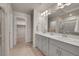 Bathroom with double sink vanity, large mirror, and a walk-in closet at 5738 N Vivian St, Arvada, CO 80002