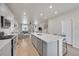 A well-lit, open-concept kitchen featuring hardwood floors, modern appliances, and views into the home's living areas at 5738 N Vivian St, Arvada, CO 80002