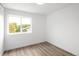 Minimalist bedroom with wood flooring and a large window, offering natural light and views of the outdoor greenery at 5462 S Cedar St, Littleton, CO 80120
