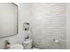 Stylish powder room with a whitewashed wood accent wall, decorative mirror, and elegant fixtures, offering a modern design at 5462 S Cedar St, Littleton, CO 80120