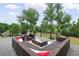 Stylish wicker outdoor seating area with cozy pillows and a glass table, surrounded by lush trees and neighborhood views at 5462 S Cedar St, Littleton, CO 80120