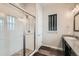 Bright bathroom with glass shower, granite countertop, and sleek fixtures, paired with dark wood-look flooring at 16546 Umatilla Place, Broomfield, CO 80023