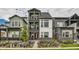 Beautiful three-story townhome featuring a red front door, stone accents, and dual upper level balconies at 16546 Umatilla Place, Broomfield, CO 80023