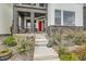 A close-up of the home's red front door, stone accents, and concrete steps at 16546 Umatilla Place, Broomfield, CO 80023