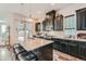 Modern kitchen with granite countertops, stainless steel appliances, dark cabinets, and bar seating at 16546 Umatilla Place, Broomfield, CO 80023