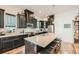 Elegant kitchen boasts granite countertops, black cabinets, and stainless appliances, complemented by bar stools at 16546 Umatilla Place, Broomfield, CO 80023