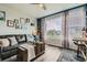 Cozy living room with a large window, hardwood floors, and a dark leather couch at 16546 Umatilla Place, Broomfield, CO 80023