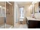 Bright bathroom features double sinks, a tiled walk-in shower, and natural light from the window at 5563 S Elk Ct, Aurora, CO 80016
