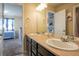 Bright bathroom with double sinks, black cabinets and a view to an additional bedroom at 5563 S Elk Ct, Aurora, CO 80016
