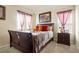 Well-lit bedroom with two windows, a bed with decorative pillows, and stylish decor at 5563 S Elk Ct, Aurora, CO 80016