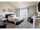 Cozy bedroom featuring neutral paint, soft carpet, a large window, and stylish decor at 5563 S Elk Ct, Aurora, CO 80016