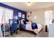 Charming bedroom featuring a cozy bed, stylish desk, and blue accent wall at 5563 S Elk Ct, Aurora, CO 80016