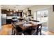 Inviting dining area featuring a dark wood table with seating for eight, adjoining a modern kitchen with stainless steel appliances at 5563 S Elk Ct, Aurora, CO 80016