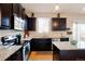 Well-equipped kitchen featuring stainless steel appliances, granite counters, dark wood cabinetry, and a cozy adjacent dining area at 5563 S Elk Ct, Aurora, CO 80016