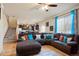 Open-concept living room features a large sectional sofa, hardwood floors, and bright natural light at 5563 S Elk Ct, Aurora, CO 80016