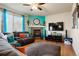 Cozy living room featuring a fireplace, comfortable seating, a flat-screen TV, and natural light from a large window at 5563 S Elk Ct, Aurora, CO 80016