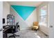 Bright office featuring a unique teal and gray accent wall, a desk, and a cozy yellow chair by a sunlit window at 5563 S Elk Ct, Aurora, CO 80016