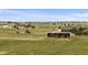 Aerial view of the property with an outbuilding and sheds amidst a picturesque landscape at 6785 Arrowhead Cir, Elizabeth, CO 80107