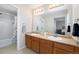 Spacious bathroom with double vanity sinks, large mirrors, and shower at 24702 E Hoover Pl, Aurora, CO 80016
