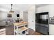 Modern kitchen open to the living room features stainless steel appliances and an island with wood countertop at 24702 E Hoover Pl, Aurora, CO 80016