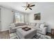 Comfortable living room featuring a large sectional sofa, a ceiling fan, and ample natural light at 24702 E Hoover Pl, Aurora, CO 80016