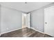 Bedroom with neutral walls, wood-look flooring, and doors to other rooms at 12154 E Virginia Dr, Aurora, CO 80012
