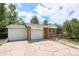 Charming brick home featuring an attached two car garage and a cracked concrete driveway at 12154 E Virginia Dr, Aurora, CO 80012