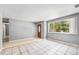 Bright and airy living room with neutral walls, tile flooring, and a large window overlooking the front yard at 12154 E Virginia Dr, Aurora, CO 80012