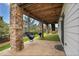 Inviting covered back patio with brick columns and cozy hammock swings for relaxing outdoors at 2314 Fairway Wood Cir, Castle Rock, CO 80109