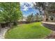 Well-manicured backyard featuring lush green lawn, stone accents, and a wooden fence offering privacy at 2314 Fairway Wood Cir, Castle Rock, CO 80109