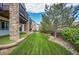 Green backyard with lush lawn, retaining wall, and mature trees, perfect for outdoor enjoyment at 2314 Fairway Wood Cir, Castle Rock, CO 80109