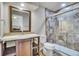 Modern bathroom with a tiled glass-door shower, wood vanity, single sink, and a large mirror, offering functionality and style at 2314 Fairway Wood Cir, Castle Rock, CO 80109