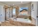 Relaxing bathroom featuring a soaking tub, tiled shower, and a large window with views at 2314 Fairway Wood Cir, Castle Rock, CO 80109