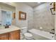 Bathroom with a tiled shower-tub combo, wooden vanity, neutral wall, and a toilet, combining functionality and a clean aesthetic at 2314 Fairway Wood Cir, Castle Rock, CO 80109