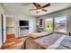 Comfortable bedroom with a ceiling fan, hardwood floors, outside view, TV on a dresser, and a cozy bed at 2314 Fairway Wood Cir, Castle Rock, CO 80109