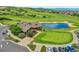 Stunning aerial view of the golf clubhouse, pond, and course with golf carts and colorful landscaping at 2314 Fairway Wood Cir, Castle Rock, CO 80109