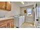 Functional laundry room featuring a washer, dryer, sink, wooden cabinets, tiled flooring and a window at 2314 Fairway Wood Cir, Castle Rock, CO 80109
