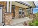 Covered front porch with stone columns and small sitting area at 2314 Fairway Wood Cir, Castle Rock, CO 80109